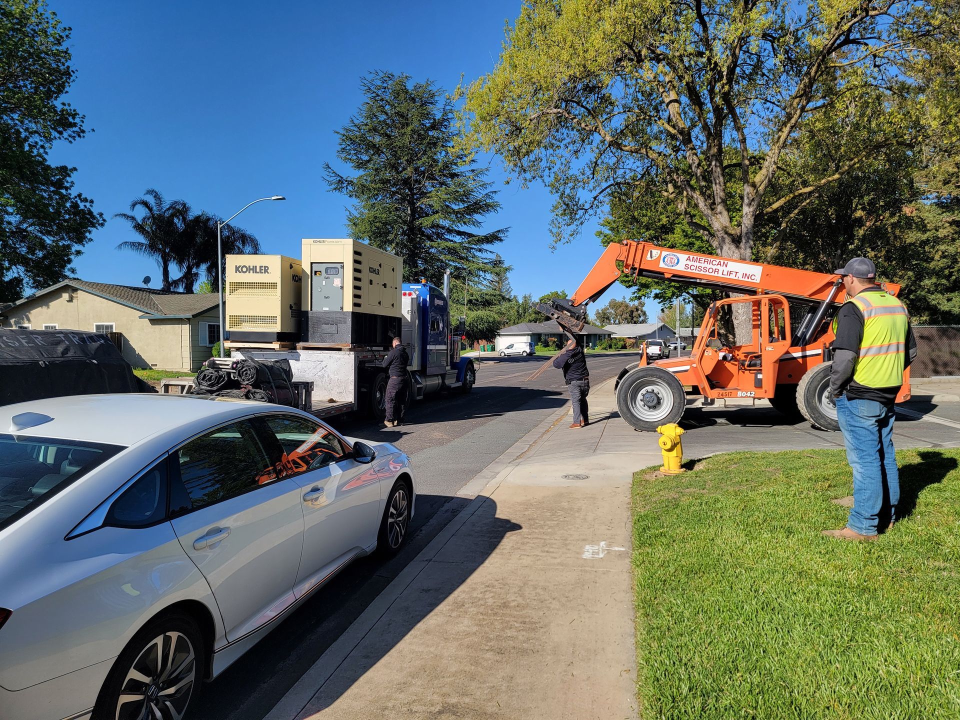 A white car is parked on the side of the road next to a fire hydrant.