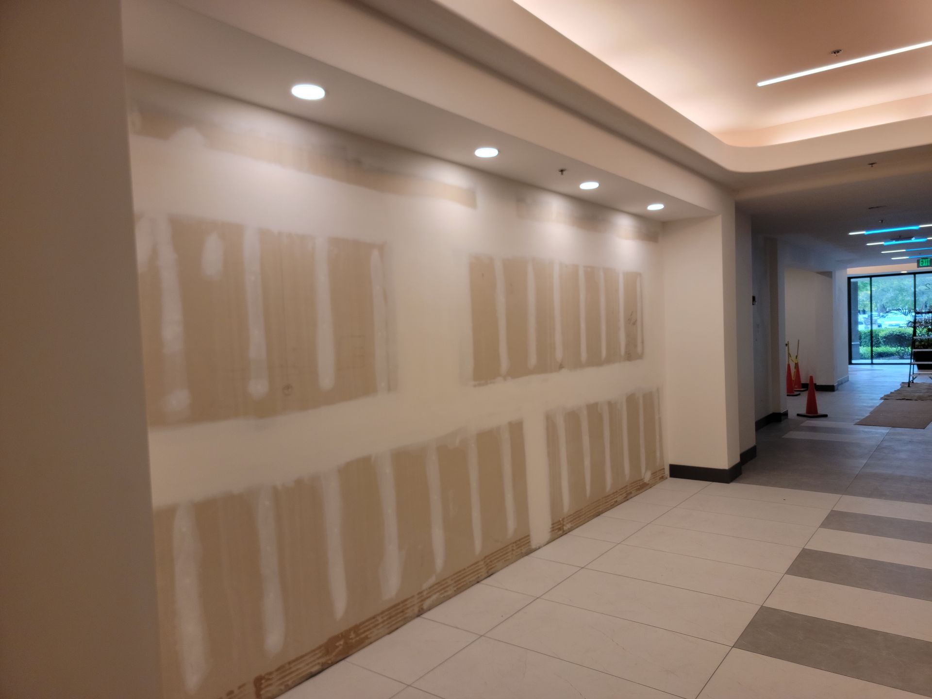 A hallway with drywall on the walls and a ceiling