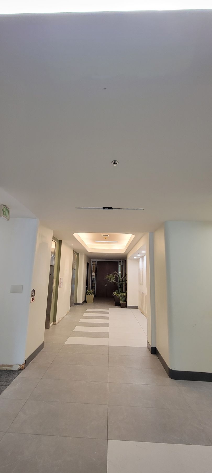 A long hallway in a building with a ceiling light.