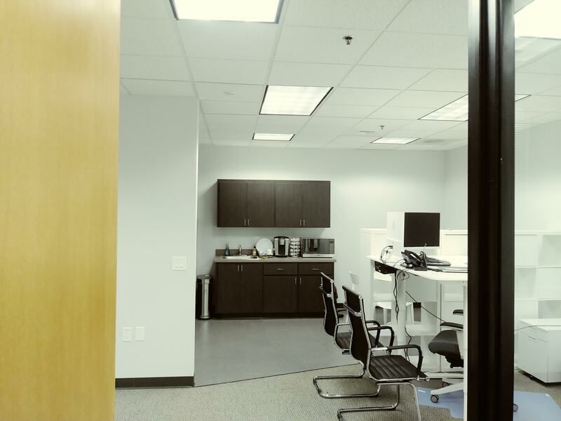 A waiting room with chairs and tables in an office