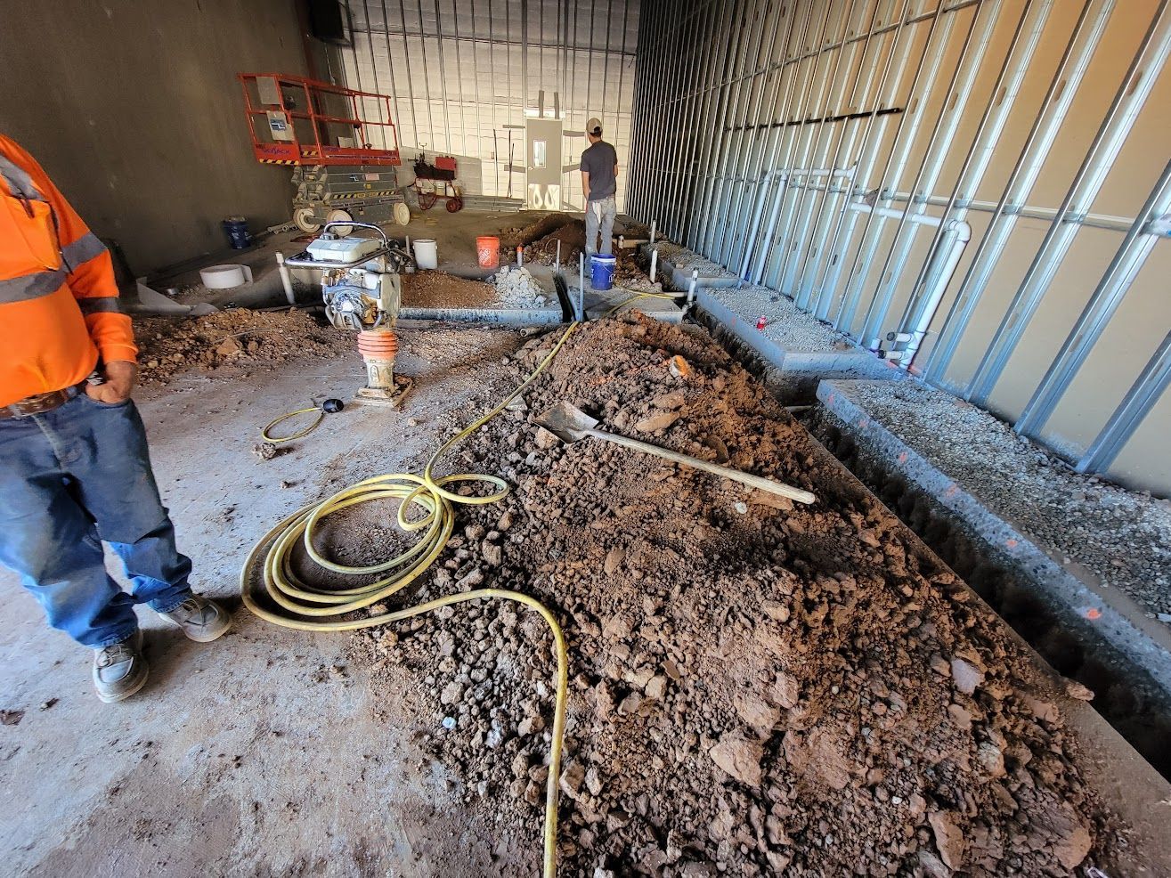 A man is standing next to a pile of dirt in a room.