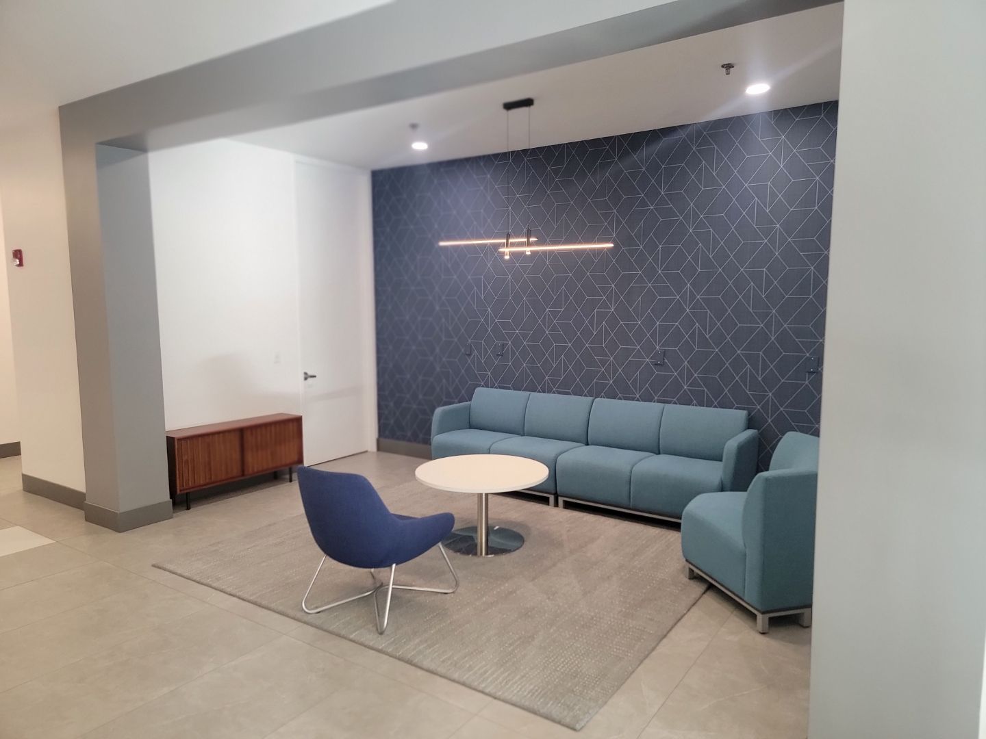 A living room with a couch , chairs , and a table.