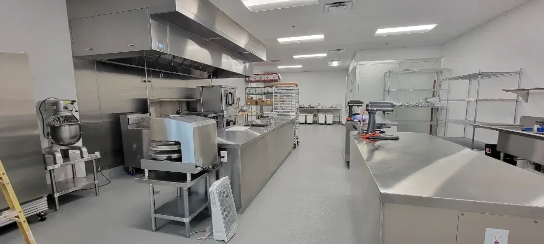 A large kitchen with a lot of stainless steel appliances.