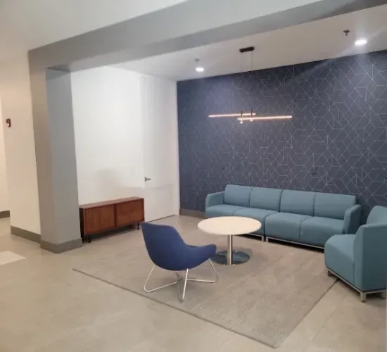 A waiting room with a couch a chair and a table