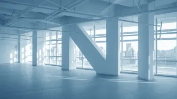 A man is standing on a ladder in a room under construction.