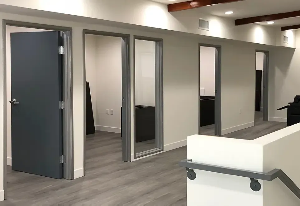 A hallway with a staircase and a lot of doors