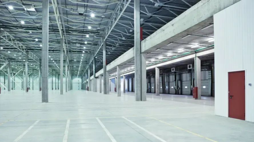 An empty warehouse with a lot of doors and columns.