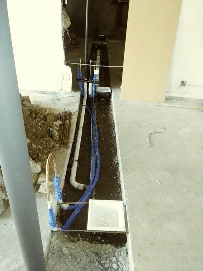 A bunch of pipes are laying on the ground in a room.