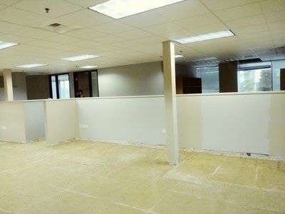 A large empty office with cubicles and a ceiling light.