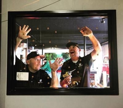 Two men are standing in front of a mirror with their hands in the air