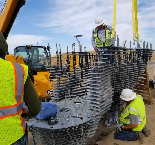 A group of construction workers are working on a large metal structure.