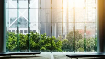 A large window with a view of a city and trees.