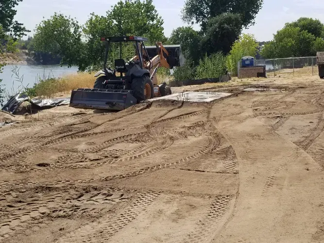 A bulldozer is moving dirt on a dirt road.
