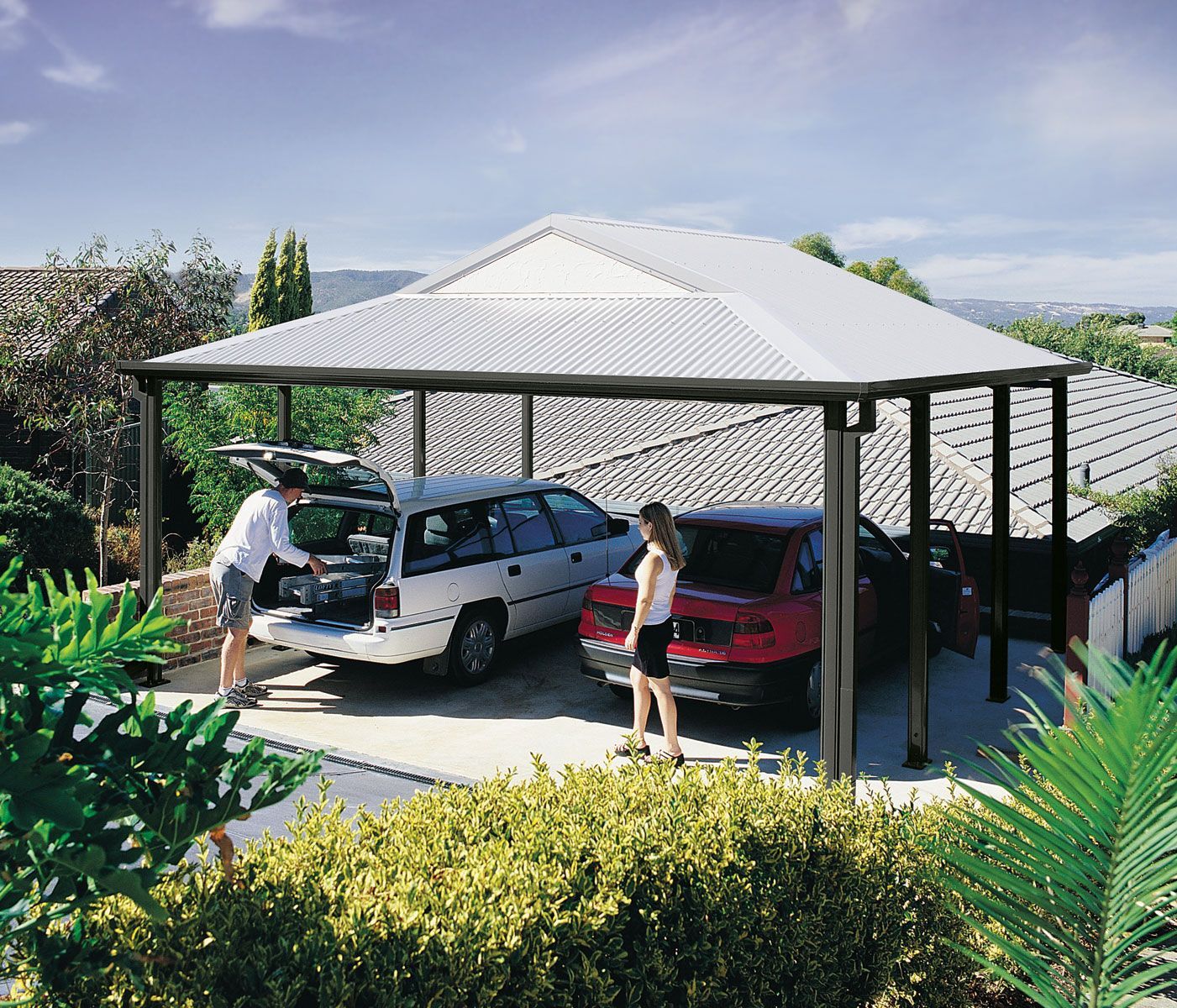 A carport builder installing a metal frame in the backyard of a home. A carport builder installing a metal frame in the backyard of a home.