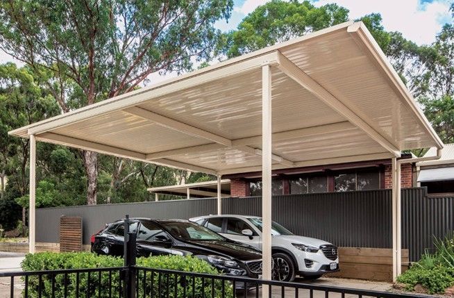 A carport builder installing a metal frame in the backyard of a home. A carport builder installing a metal frame in the backyard of a home.