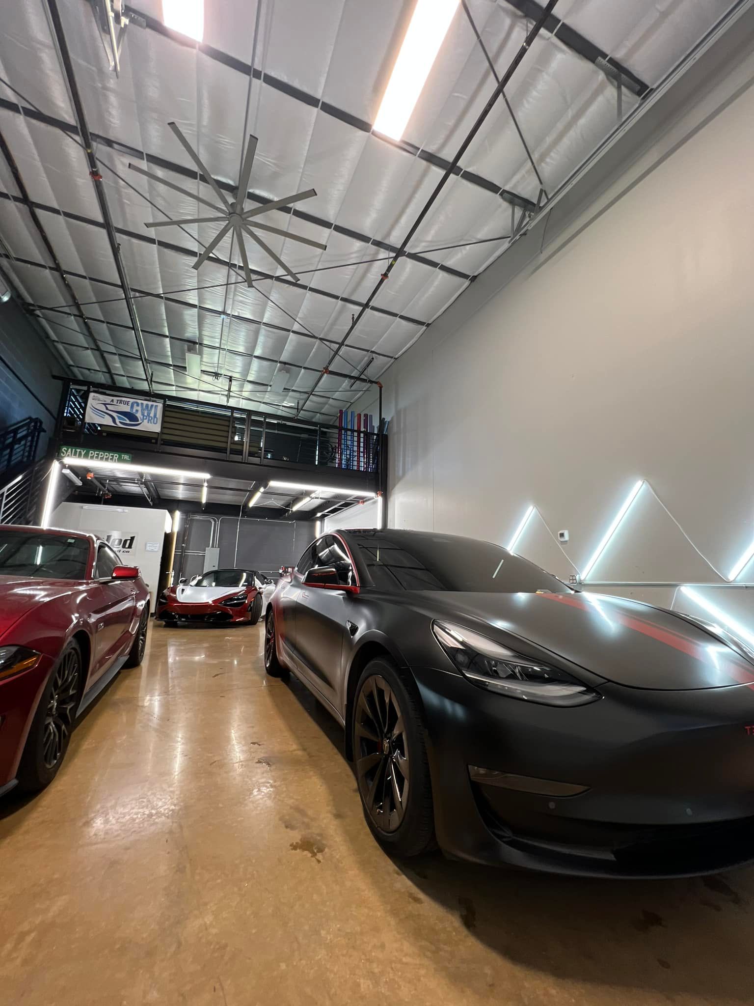 A row of cars are parked in a garage.