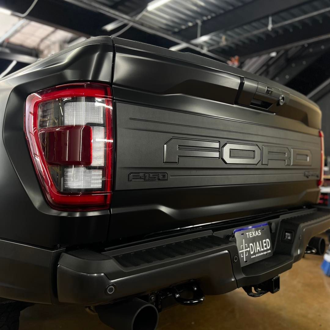 A black ford truck is parked in a garage.
