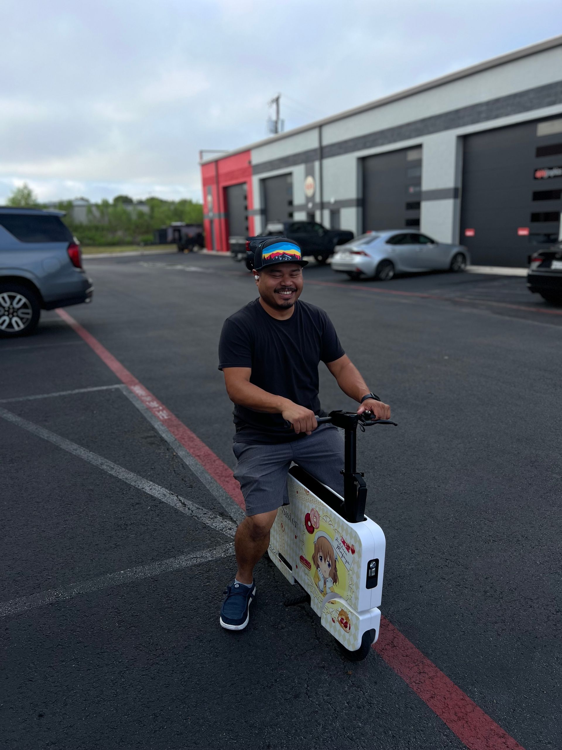 A man is riding a scooter in a parking lot