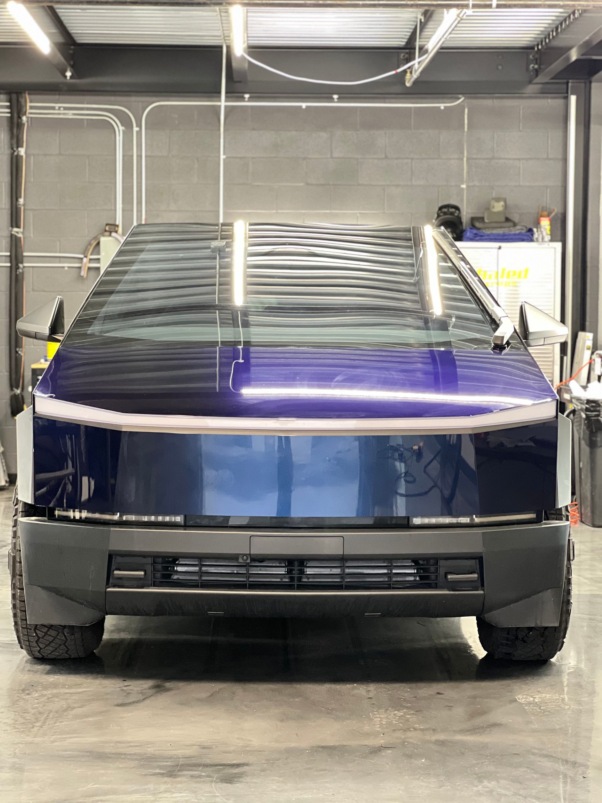 A tesla cybertruck is parked in a garage.