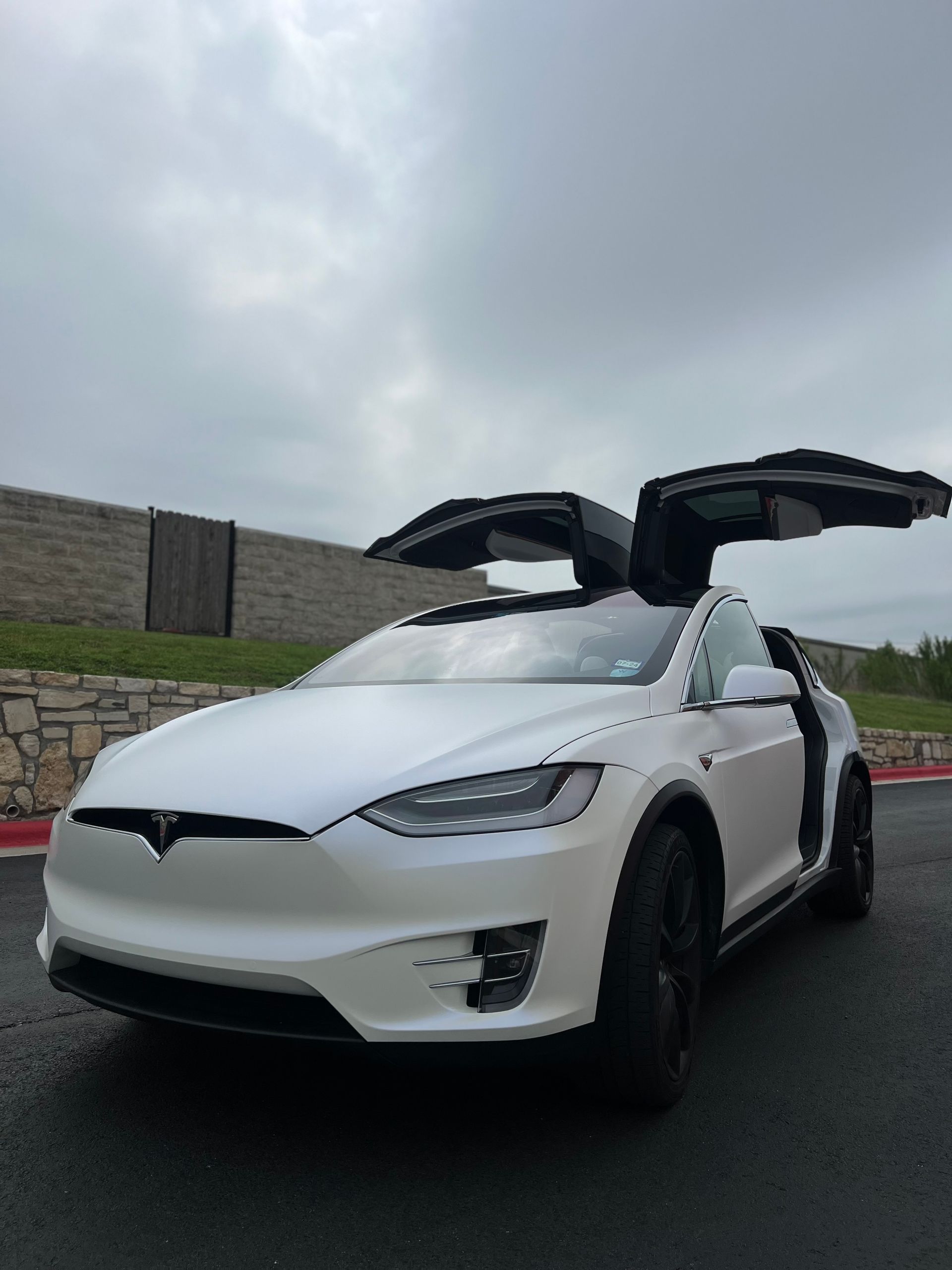 A white tesla model x with its doors open