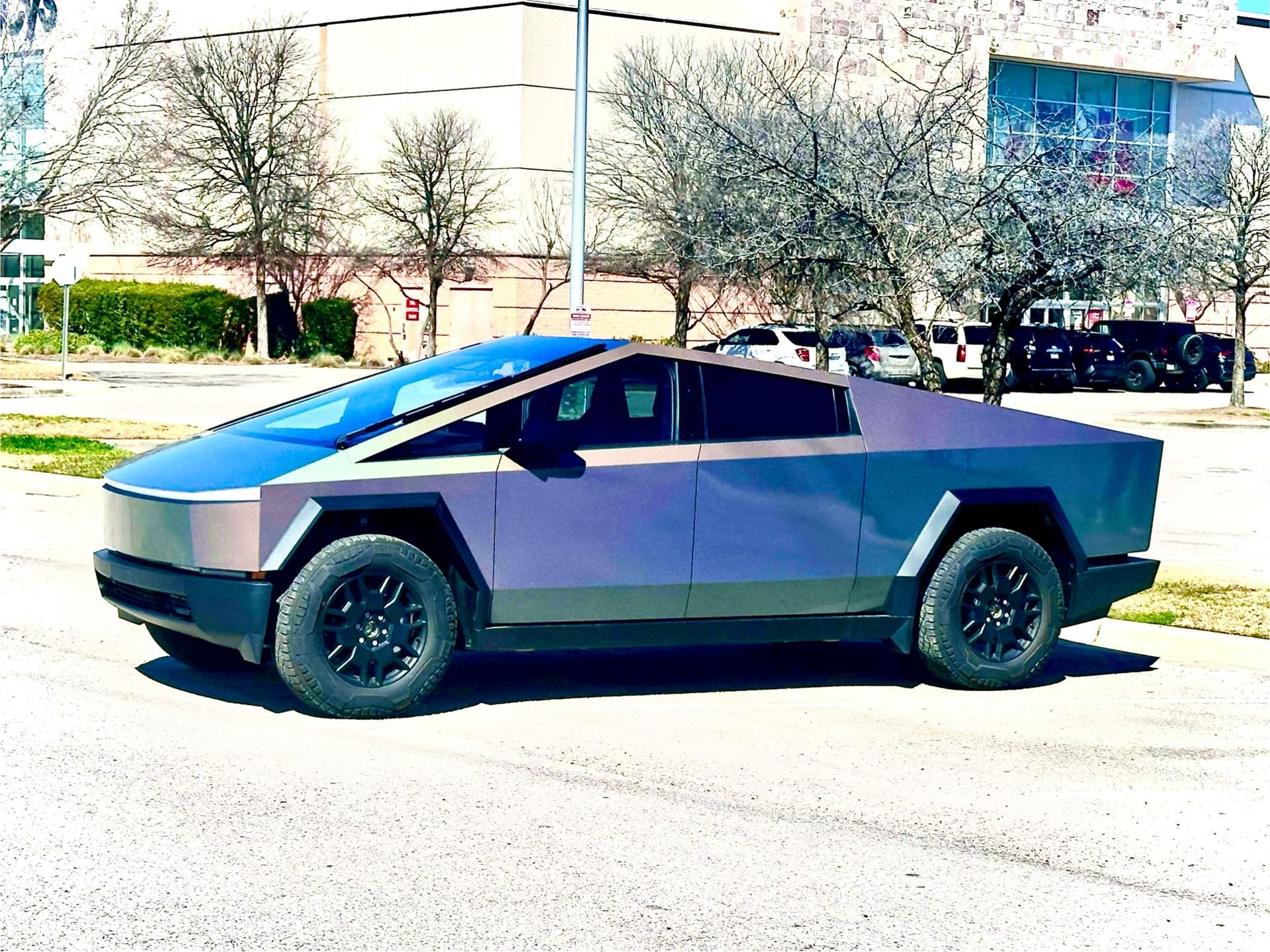 A tesla cybertruck is parked on the side of the road.