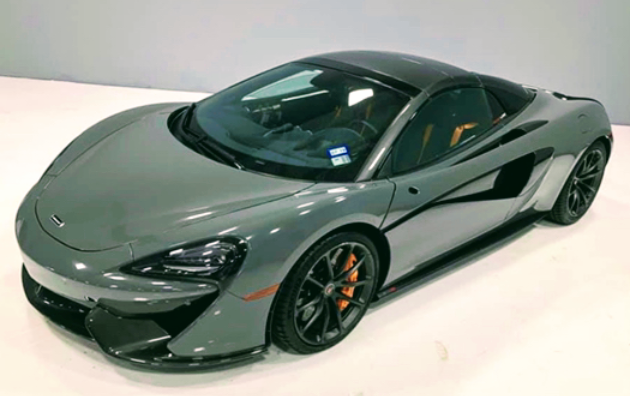 A gray sports car is sitting on a white table.