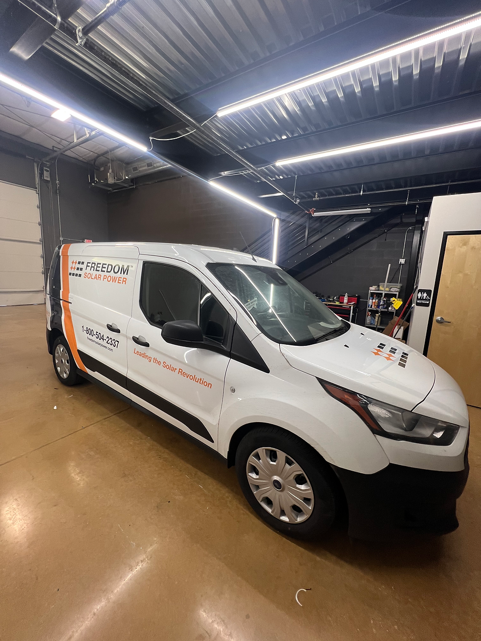 A white van is parked in a garage.