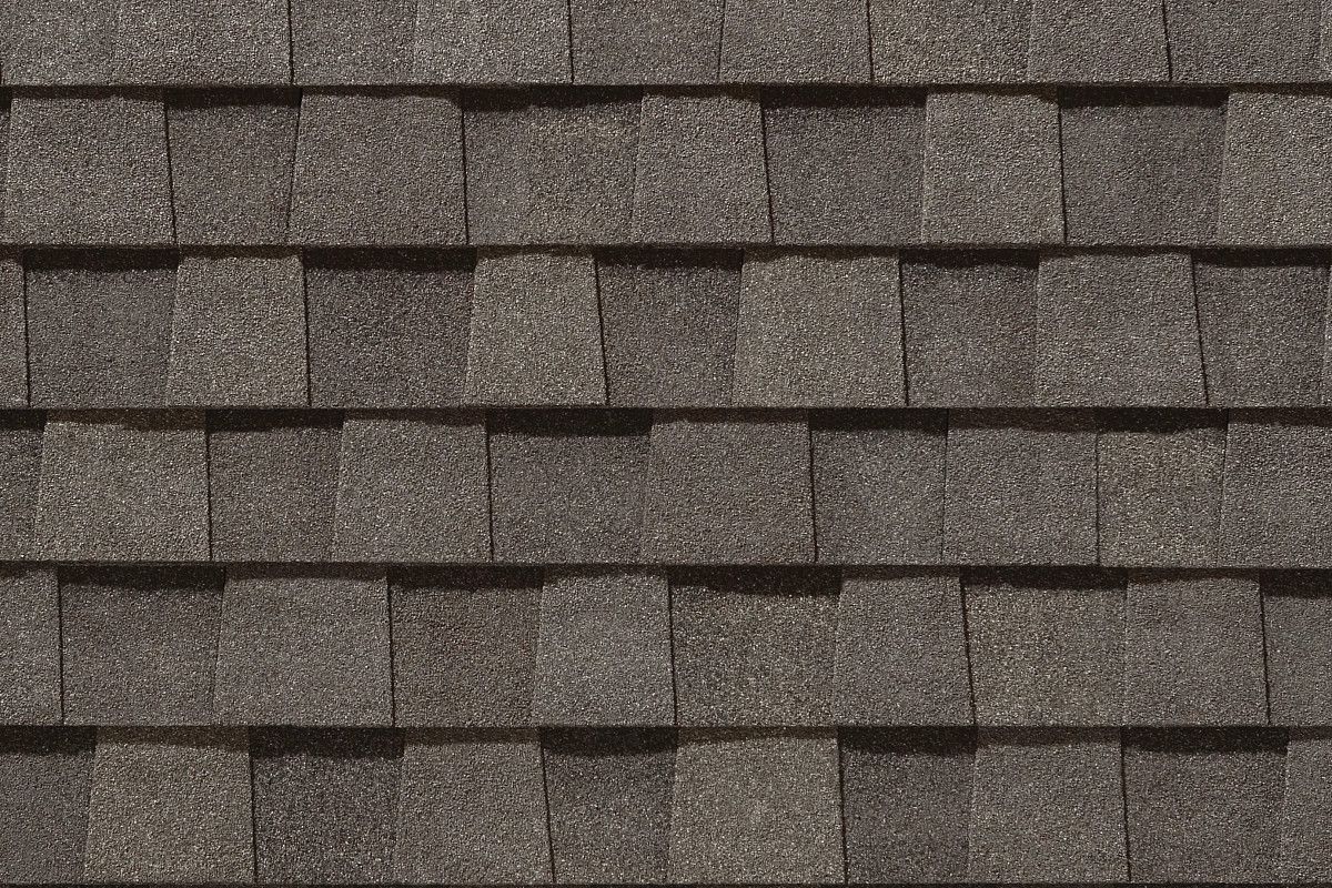 Close-up of overlapping gray asphalt roof shingles.