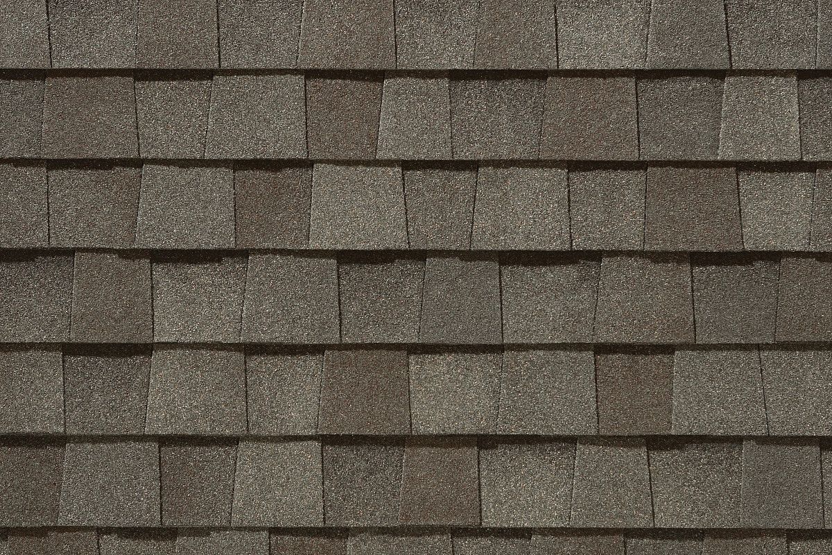 Close-up of brown asphalt roof shingles in a staggered pattern.