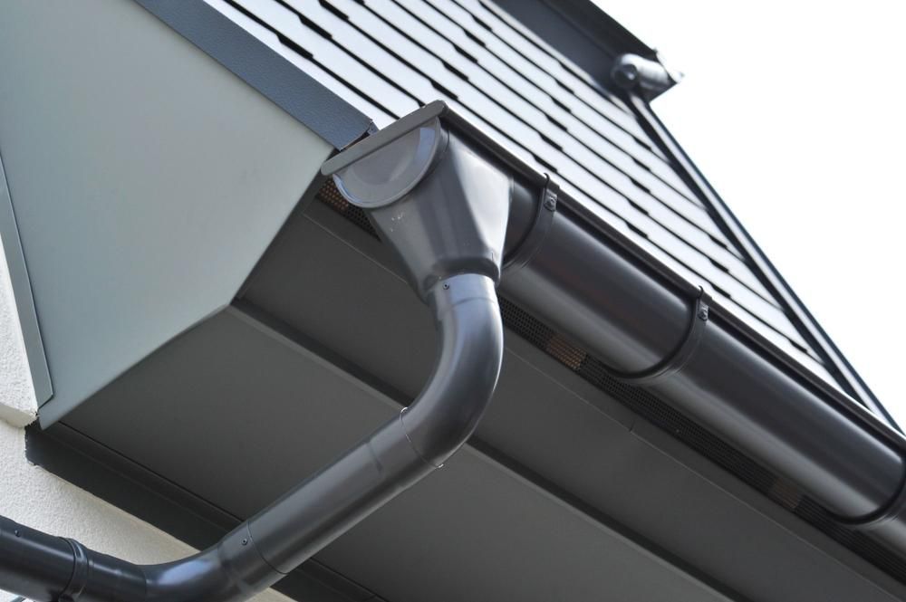 A Black Gutter on the Side of a Building — Stephen Meaker Roofing in Wagga Wagga, NSW