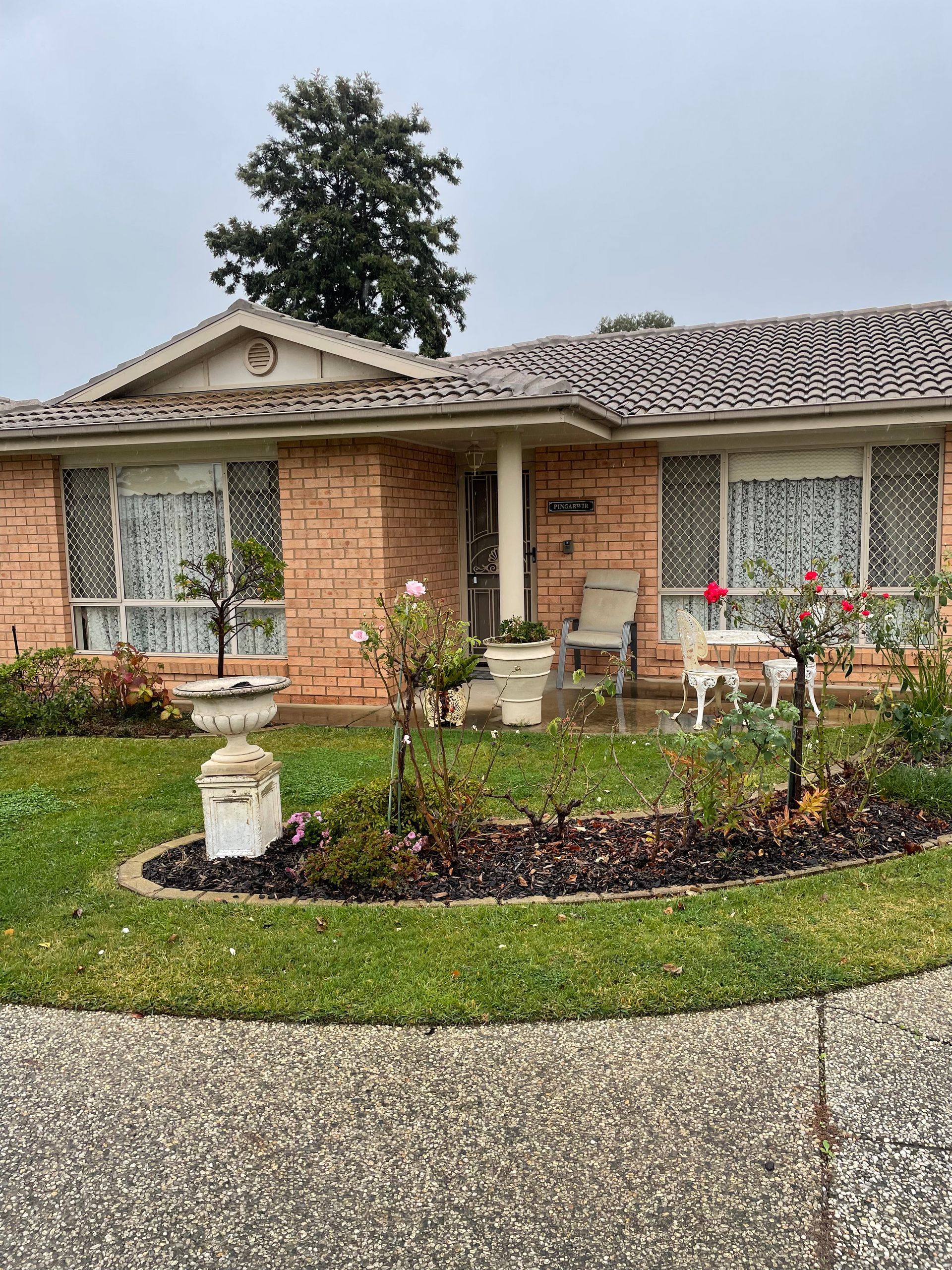 An aerial view of a tiled roof with a white car parked on the side of the road — Stephen Meaker Roofing in Wagga Wagga, NSW