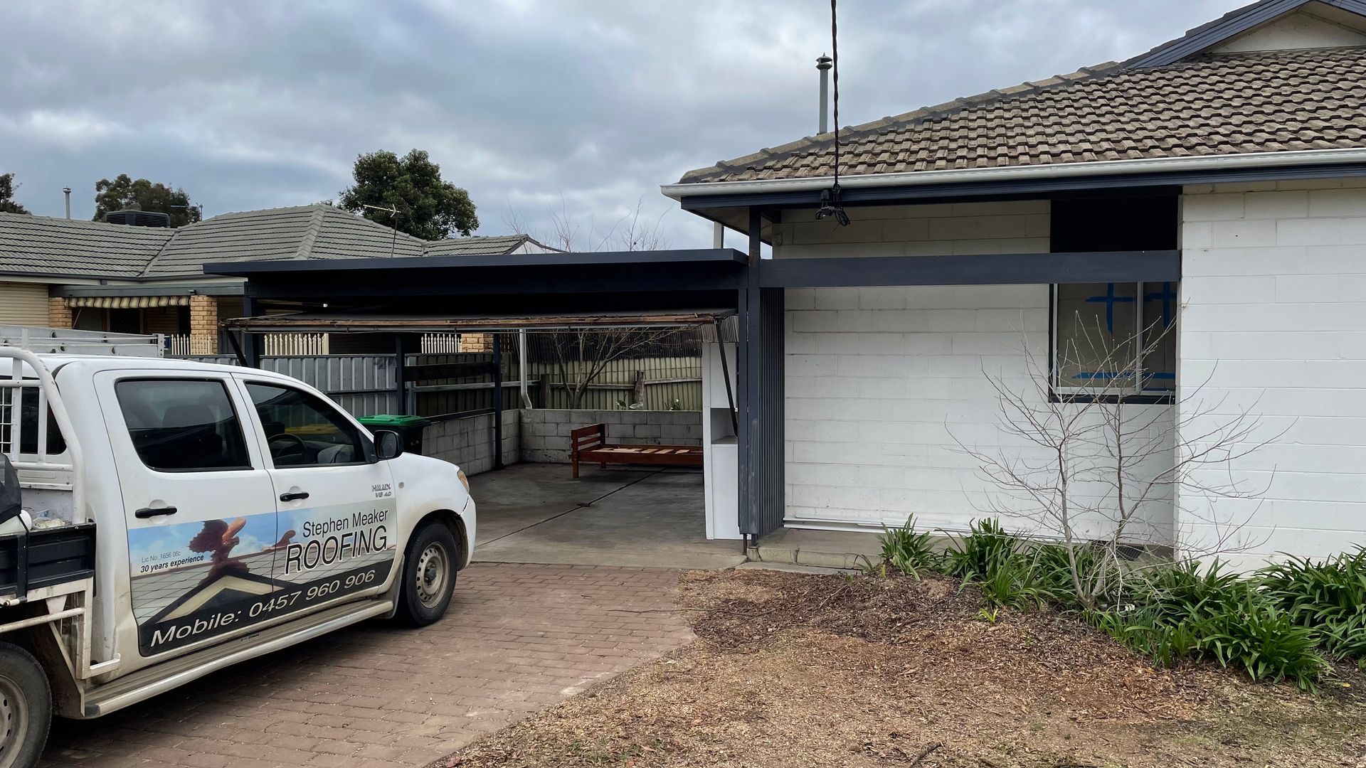 A white truck is parked in front of a white house — Stephen Meaker Roofing in Wagga Wagga, NSW