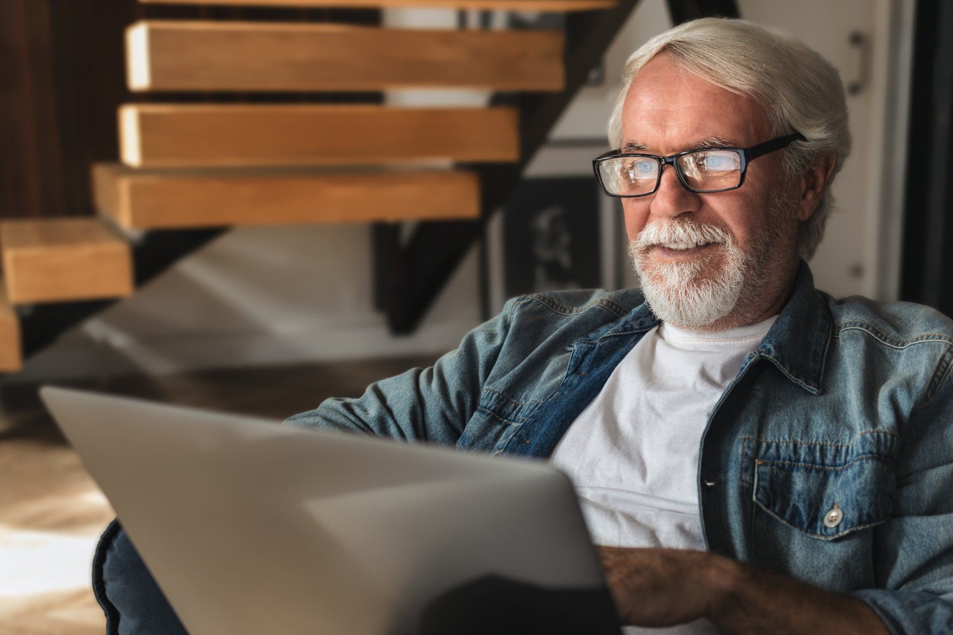 Male business owner happily using laptop to research the market