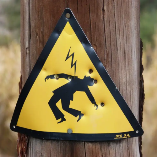 A yellow and black sign with a lightning bolt on it