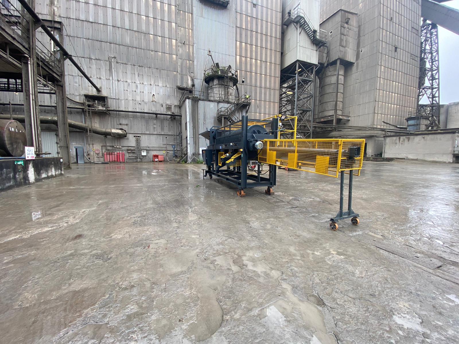 A machine is sitting in a parking lot in front of a large building.