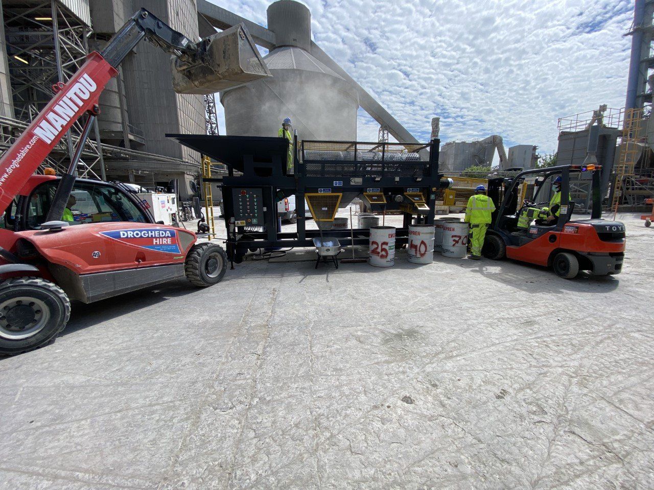 A manitou truck is parked in a parking lot next to a forklift.