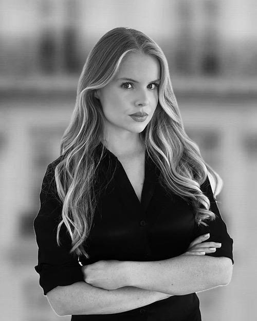 a black and white photo of a woman with her arms crossed .