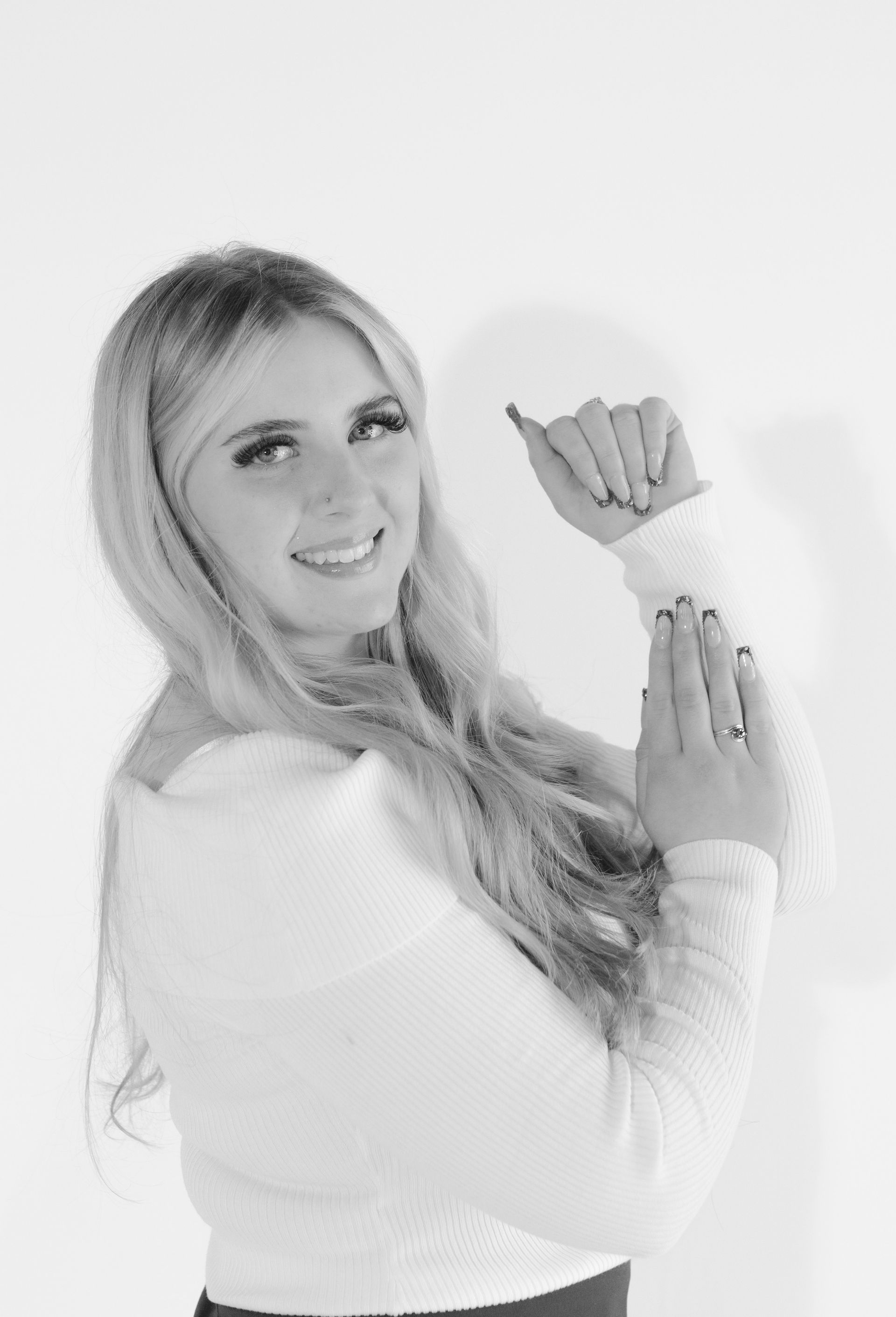A black and white photo of a woman making a hand gesture.