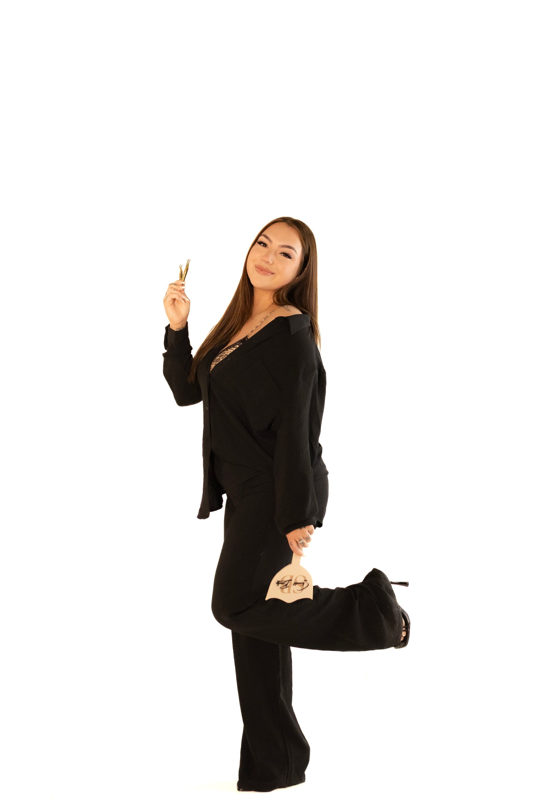 A woman in a black suit is standing on one leg.