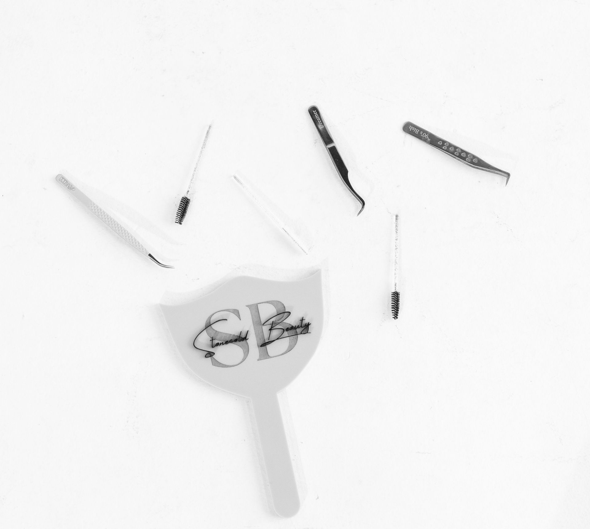 A black and white photo of a hand holding a pair of scissors.