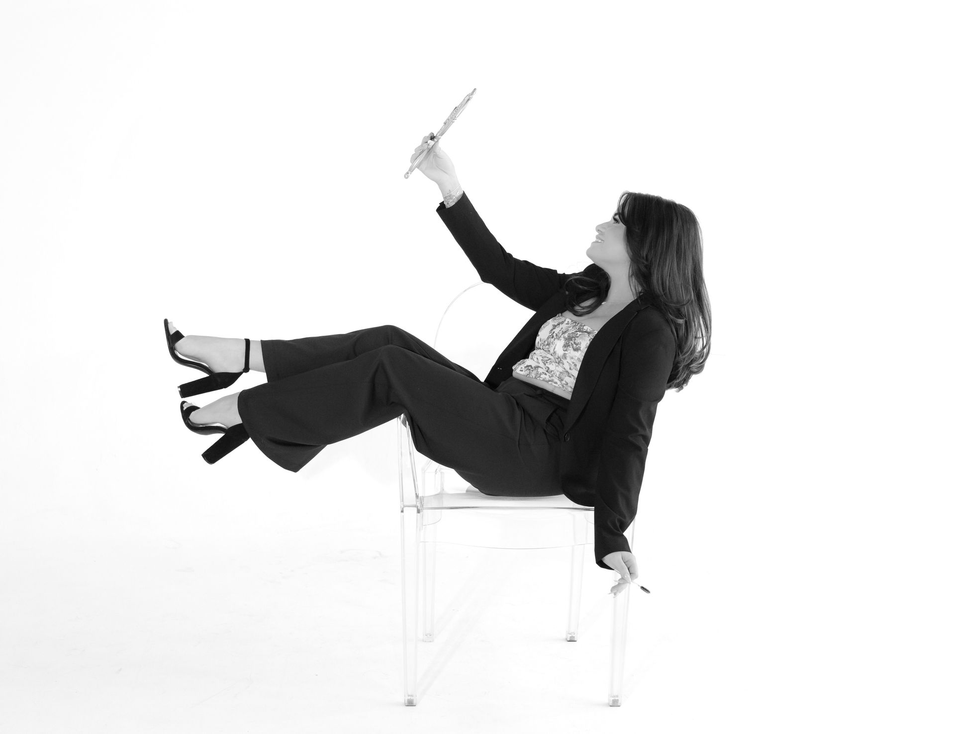 A woman is sitting on a chair holding a pen in her hand.