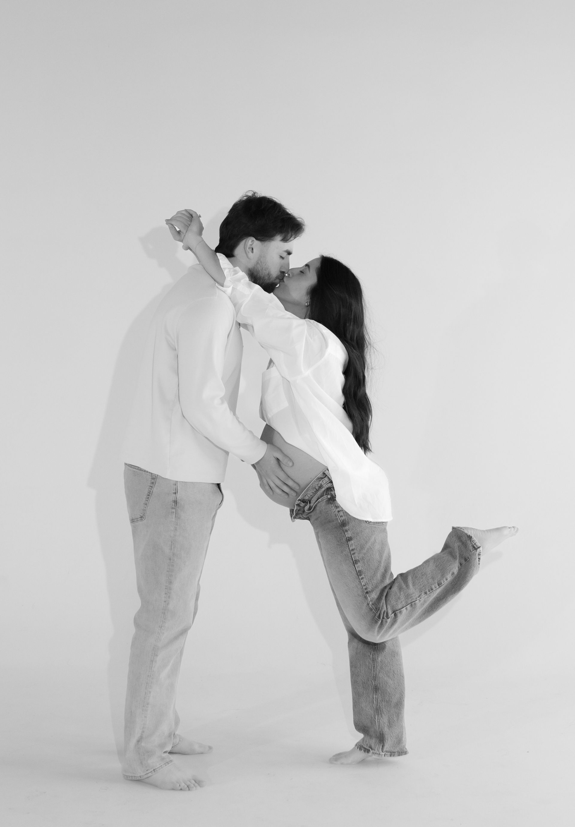 A man is holding a woman in his arms and kissing her.