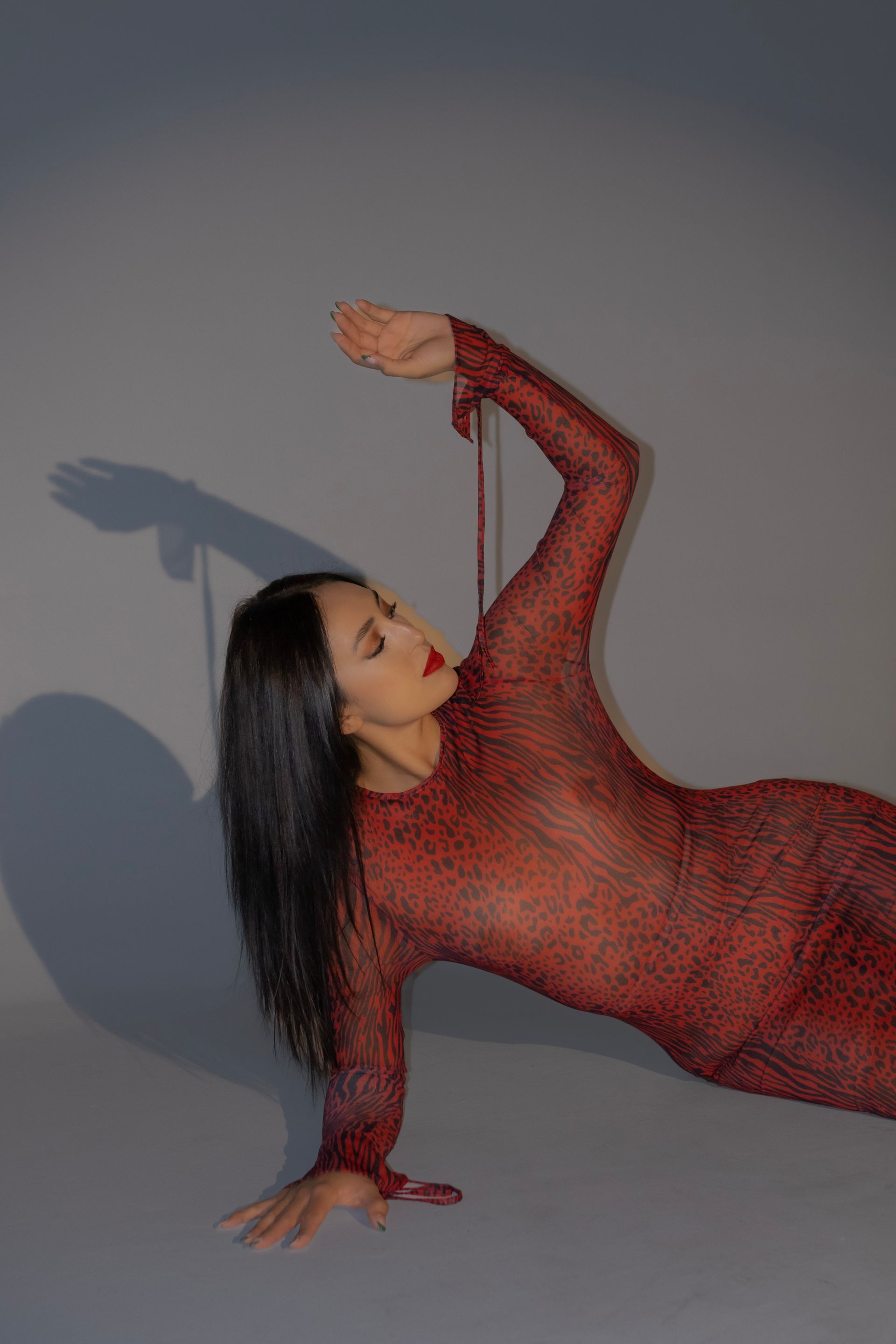 A woman in a red dress is laying on the floor.