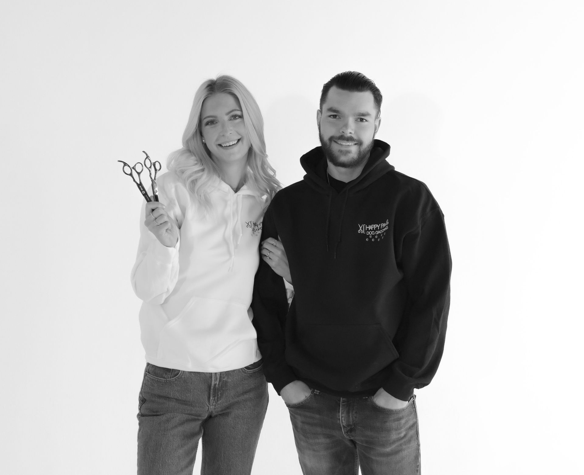 A man and a woman are standing next to each other holding scissors.