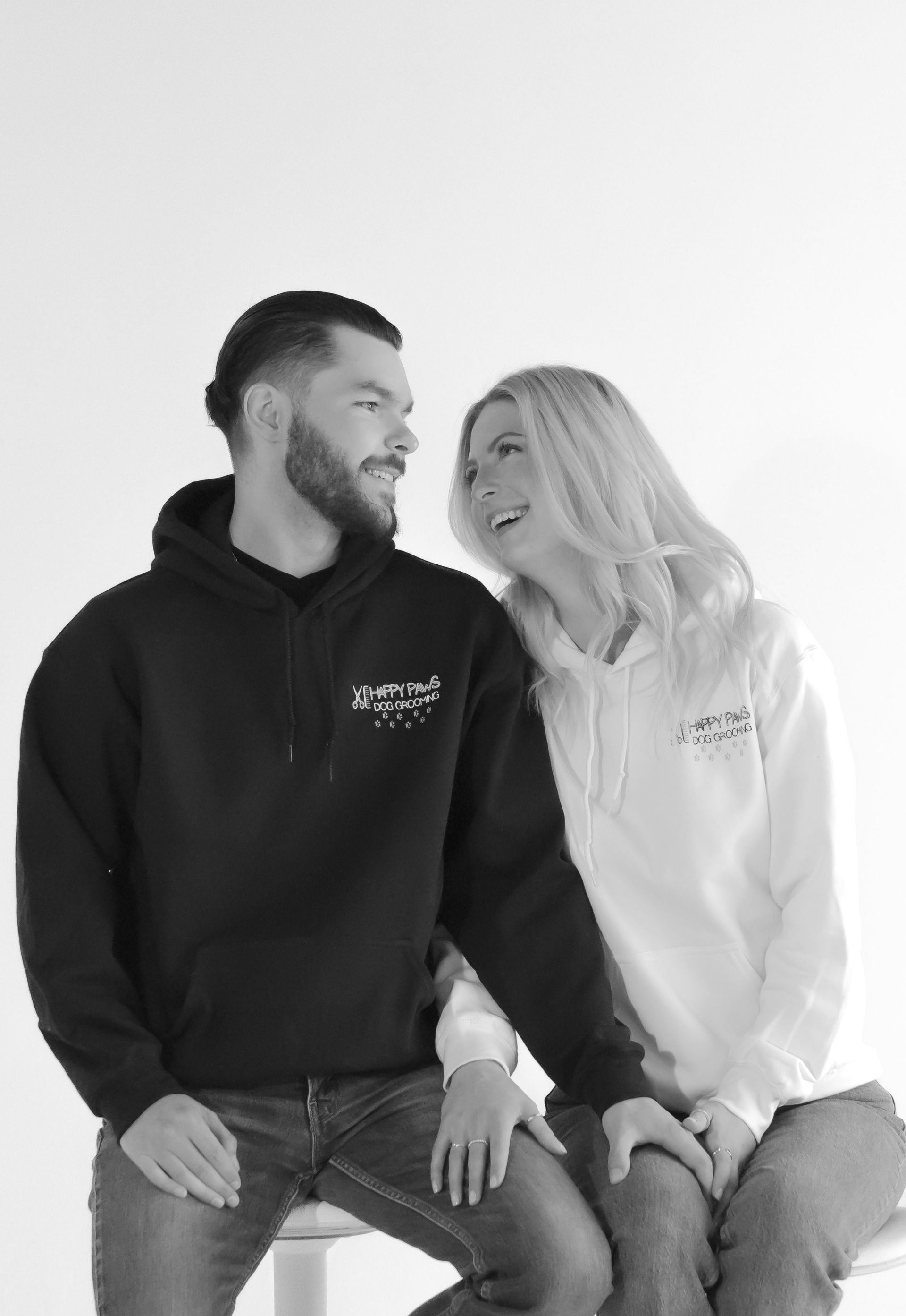 A man and a woman are sitting next to each other on a stool.