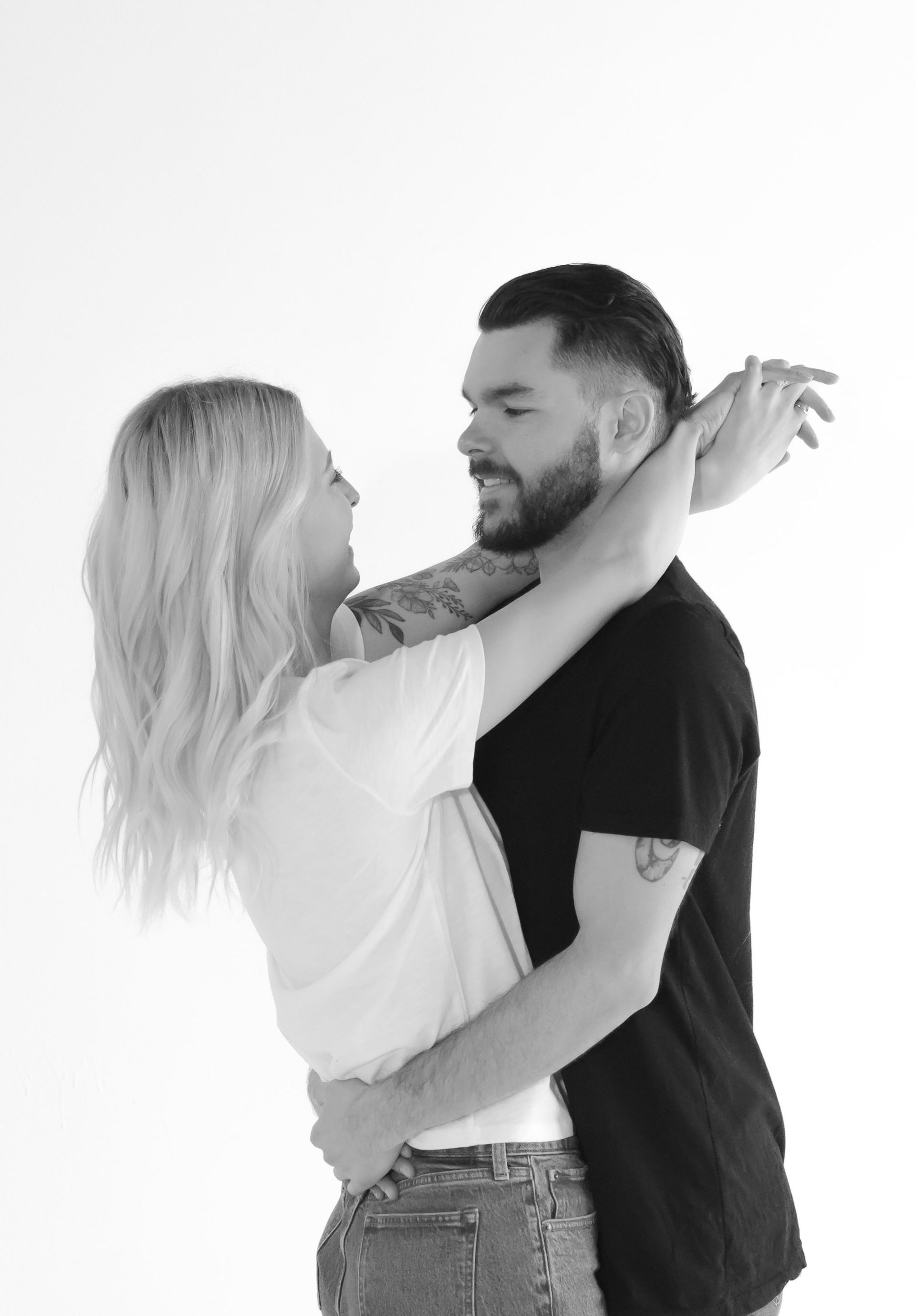 A man and a woman are hugging each other in a black and white photo.