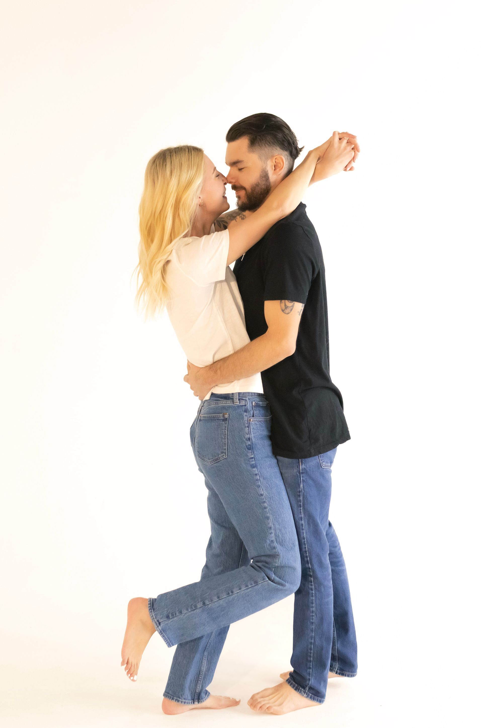 A man and a woman are dancing together on a white background.