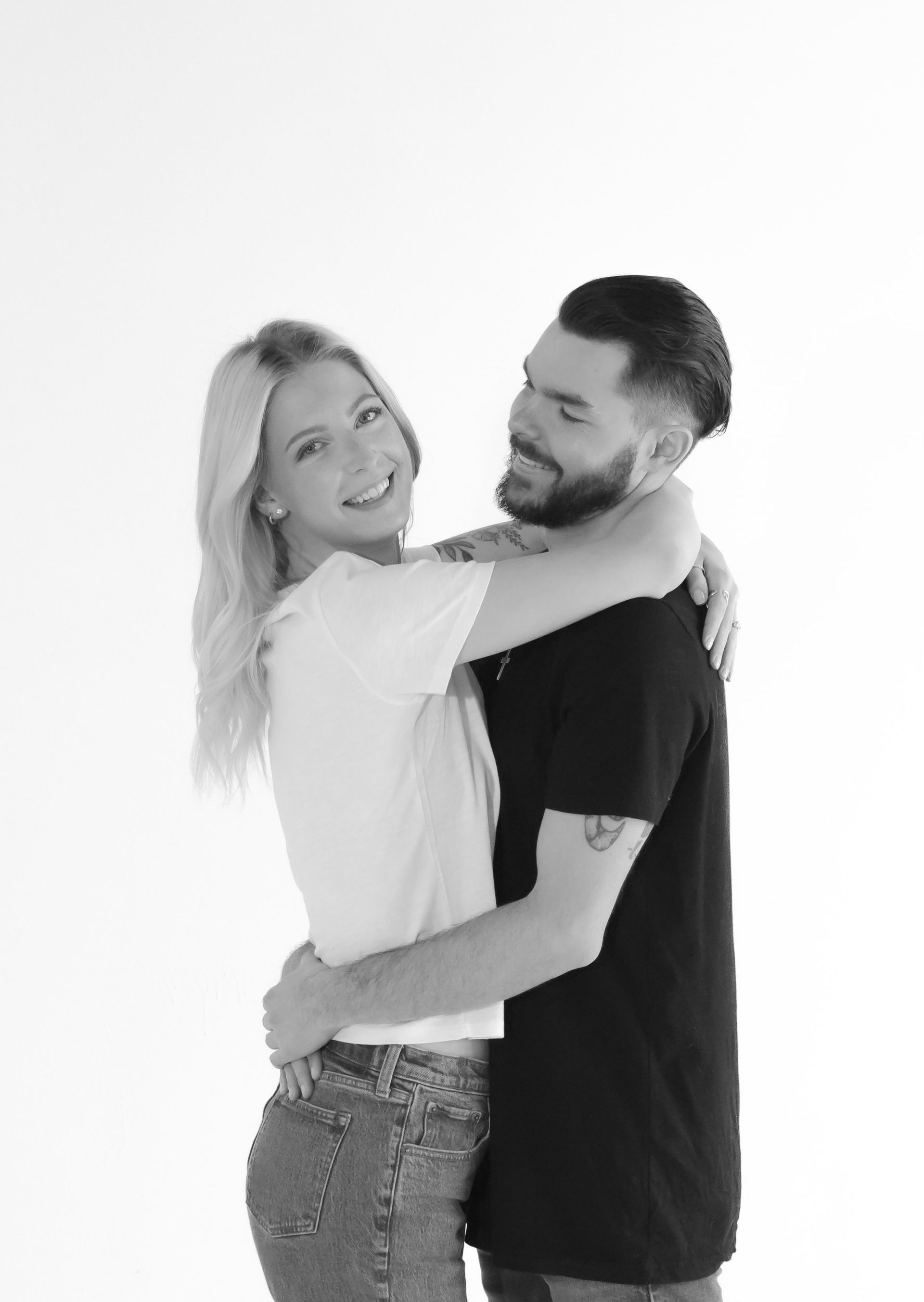 A man and a woman are hugging each other in a black and white photo.