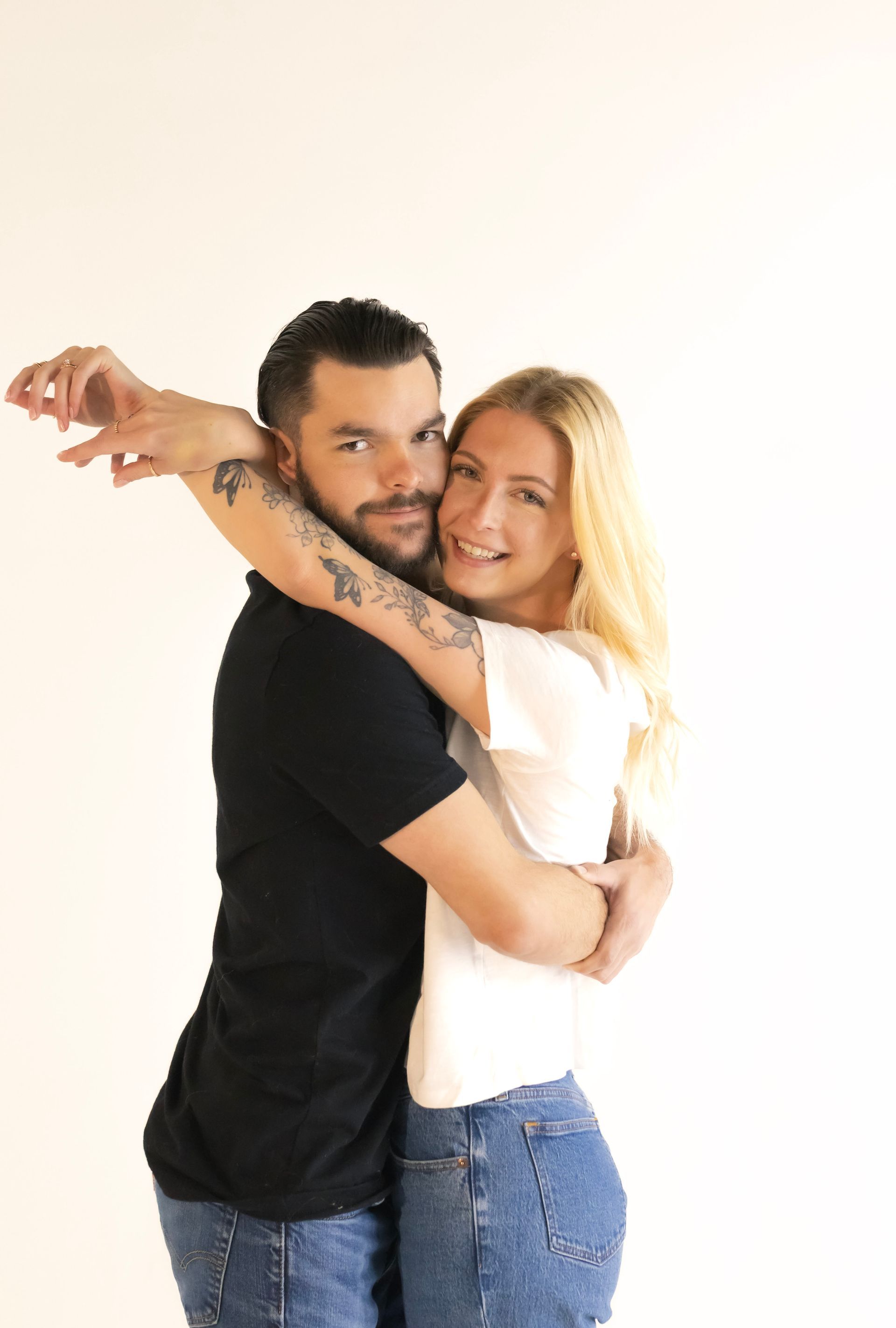 A man and a woman are hugging each other on a white background.