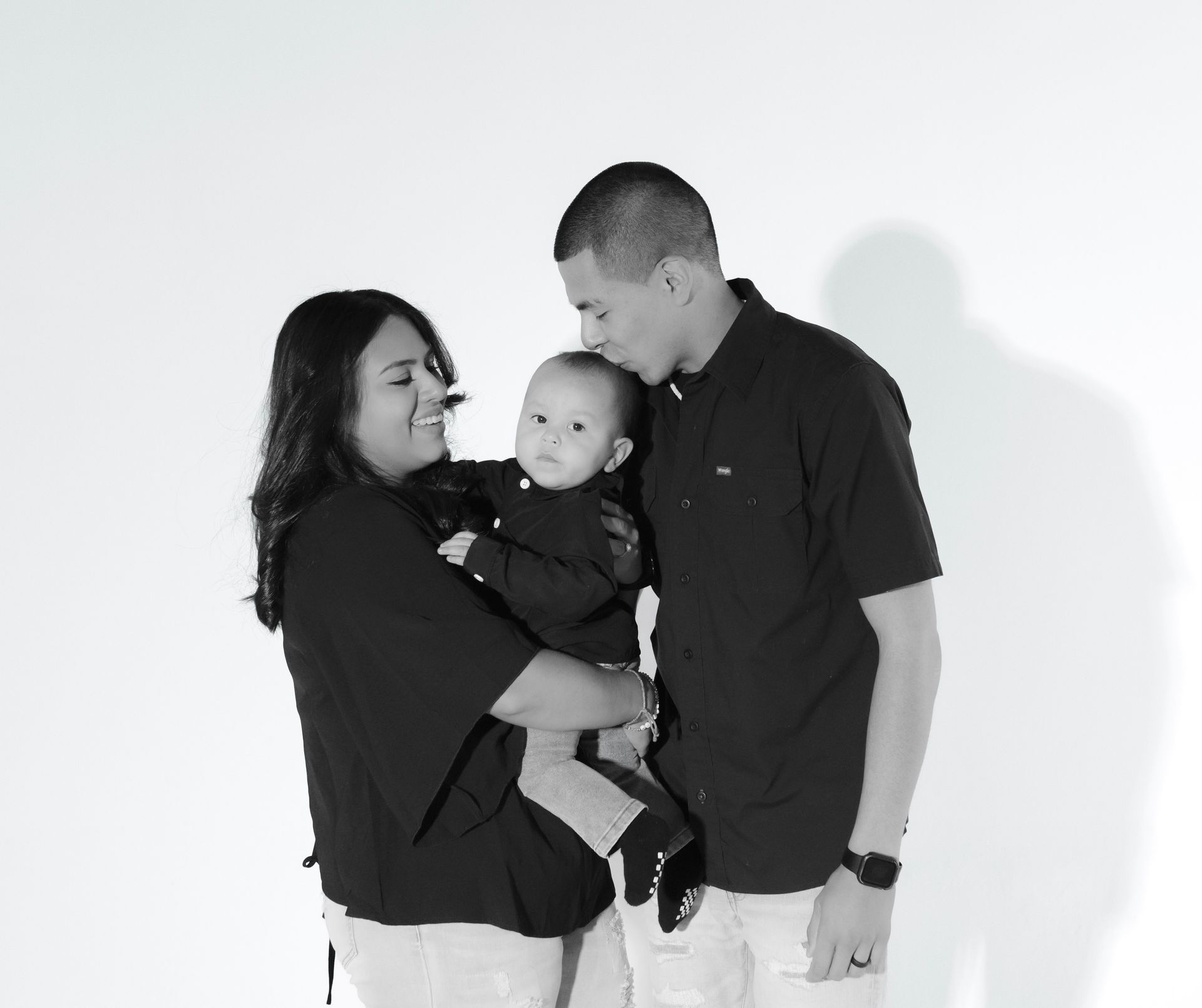 A black and white photo of a family holding a baby